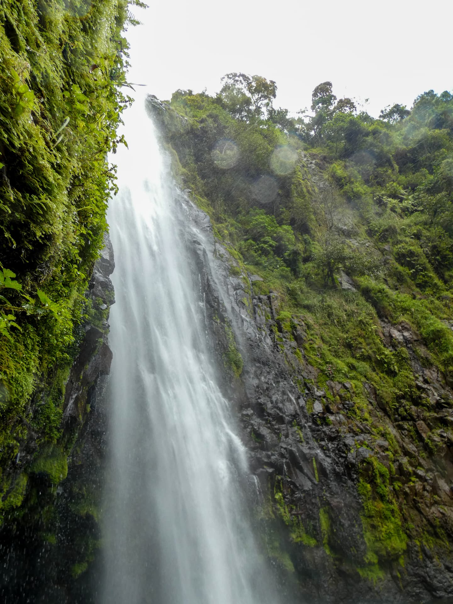 Close-up of Materuni waterfall cascading between mossy rocks